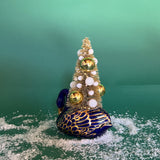 back of a Vintage Blue/Gold Ceramic Swan w/Gold Christmas Tree Centerpiece against a green background. 