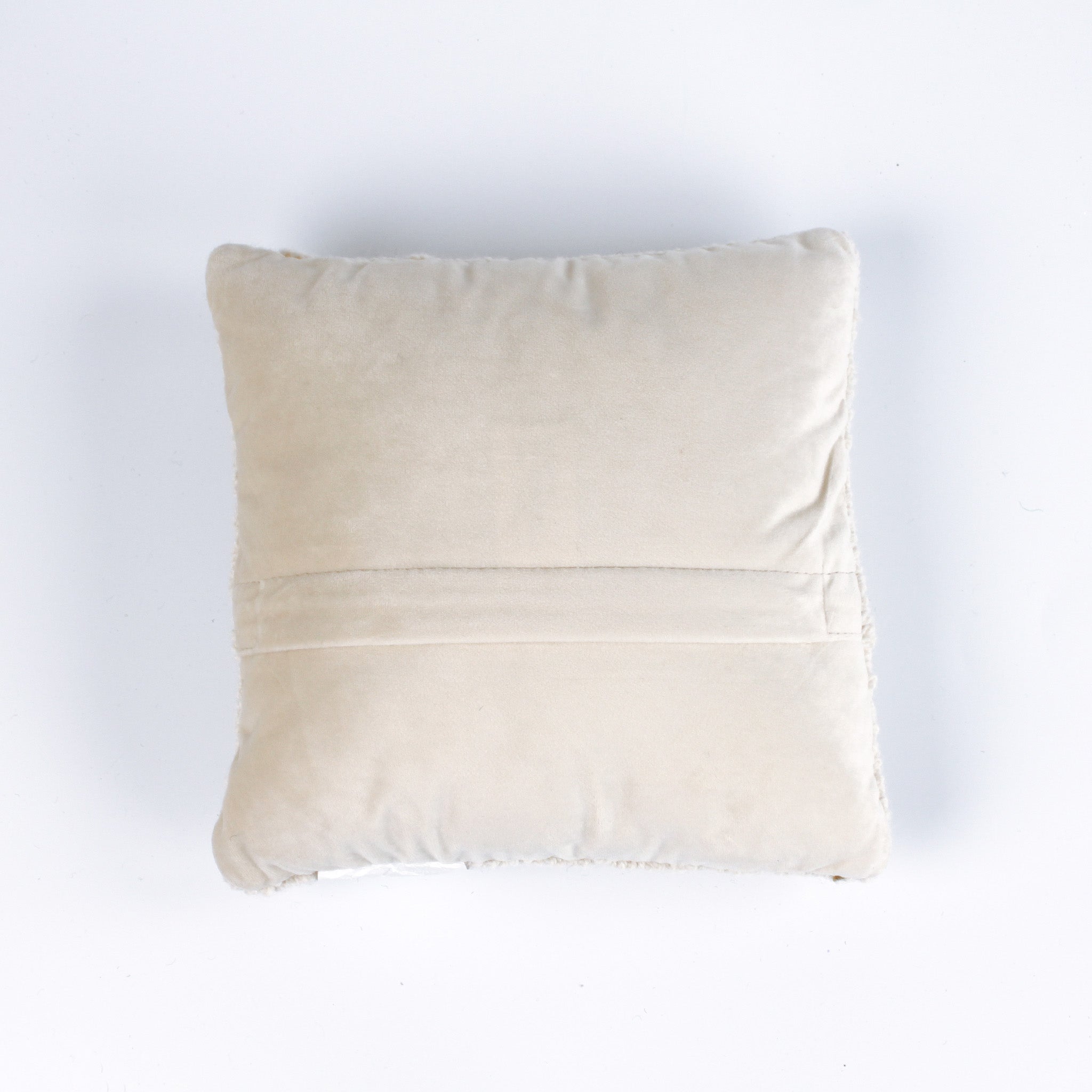 A white pillow featuring a dark blue anchor design with a tan rope wrapped around it back view