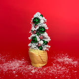 The back of a yellow coloured Vintage Distressed Ceramic Swan centerpiece with a Flocked Christmas Tree inside it against a red background. 