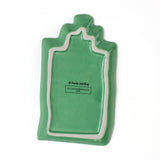Reverse side of a green christmas accent plate in the shape of a christmas gift. 