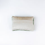 reverse back of a Rectangular green decorative pillow with a hooked texture, featuring a colorful pattern of golf tees in white, red, blue, yellow, and peach tones.