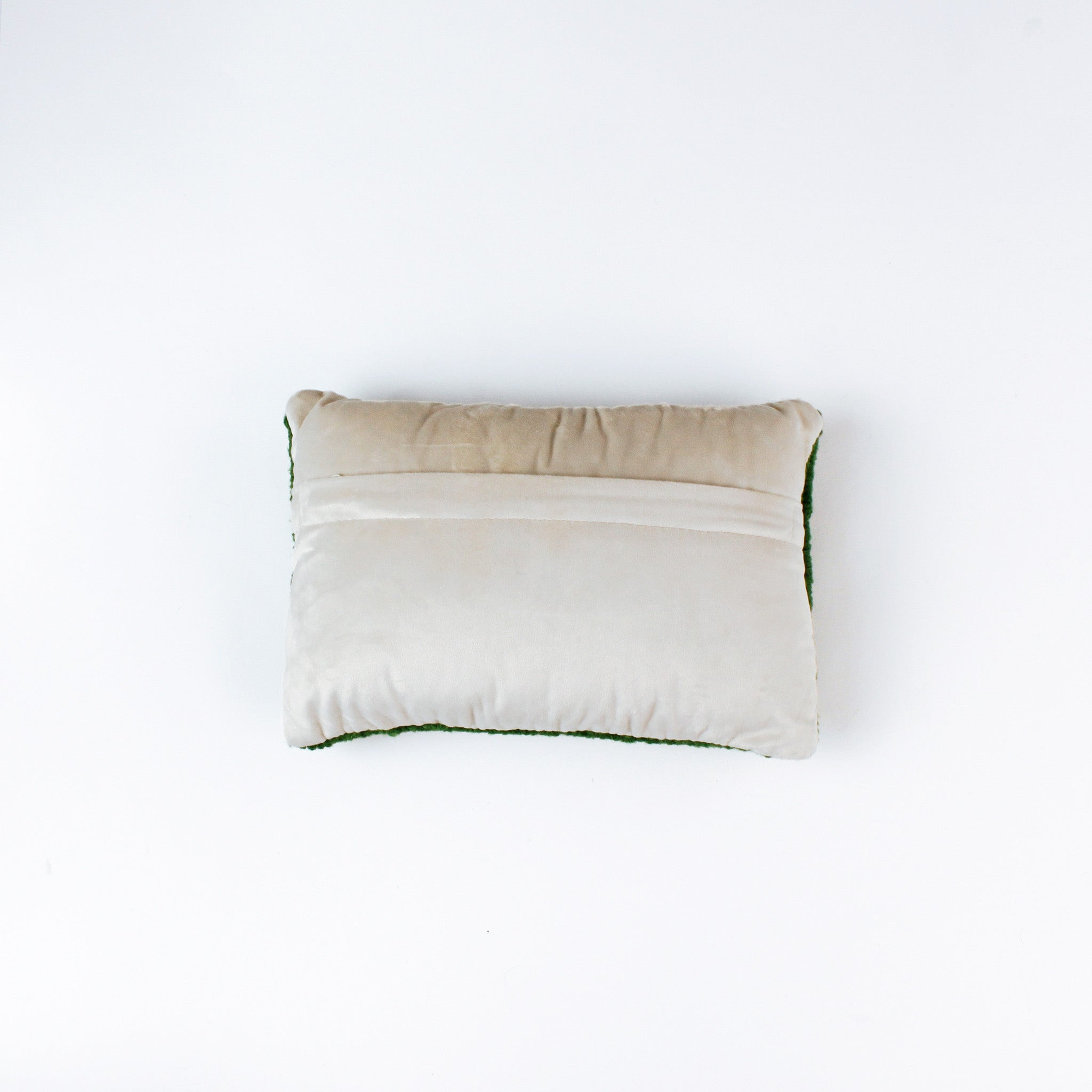 reverse back of a Rectangular green decorative pillow with a hooked texture, featuring a colorful pattern of golf tees in white, red, blue, yellow, and peach tones.