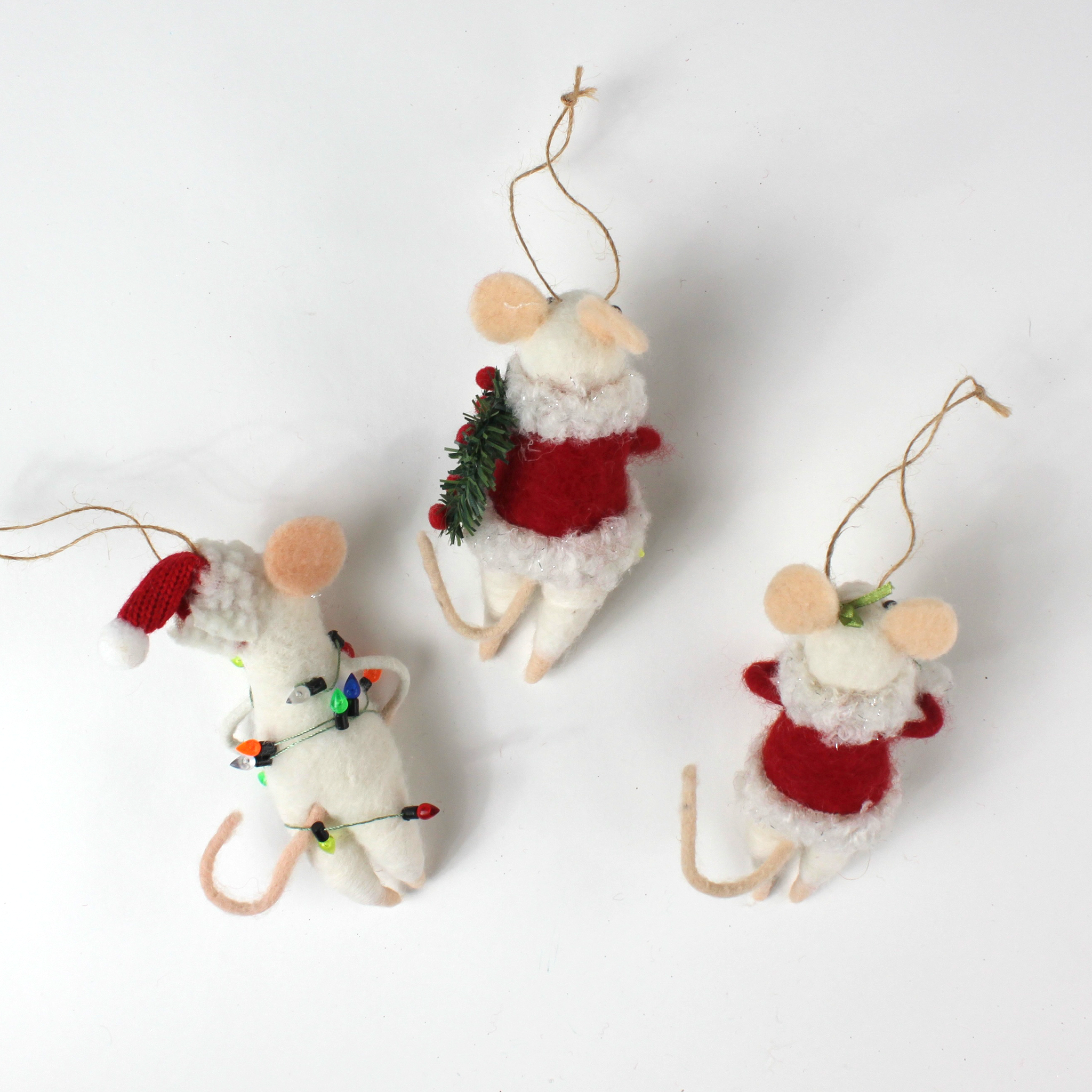 back of the Three white felt mouse ornaments where 2 dressed in cozy winter outfits, one wrapped in colorful holiday lights, one holding a Christmas wreath, and one holding a festive ornament