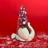 back of a White Vintage Arched-Neck Ceramic Swan w/Pink Glitter Christmas Tree Centerpiece against a red background. 