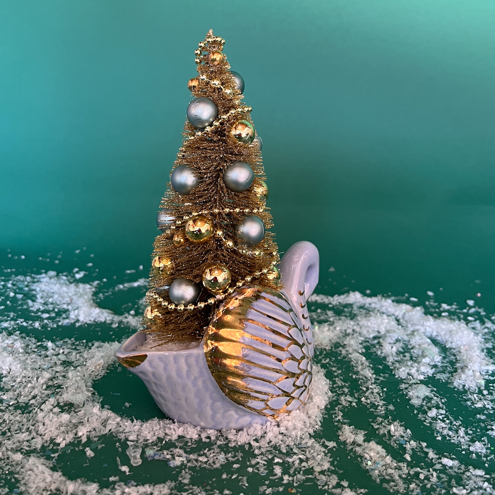 back of a Vintage White/Gold Ceramic Swan w/Gold Christmas Tree Centerpiece against a green background. 