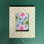 A green and white photo frame featuring a trellis pattern from madcap cottage