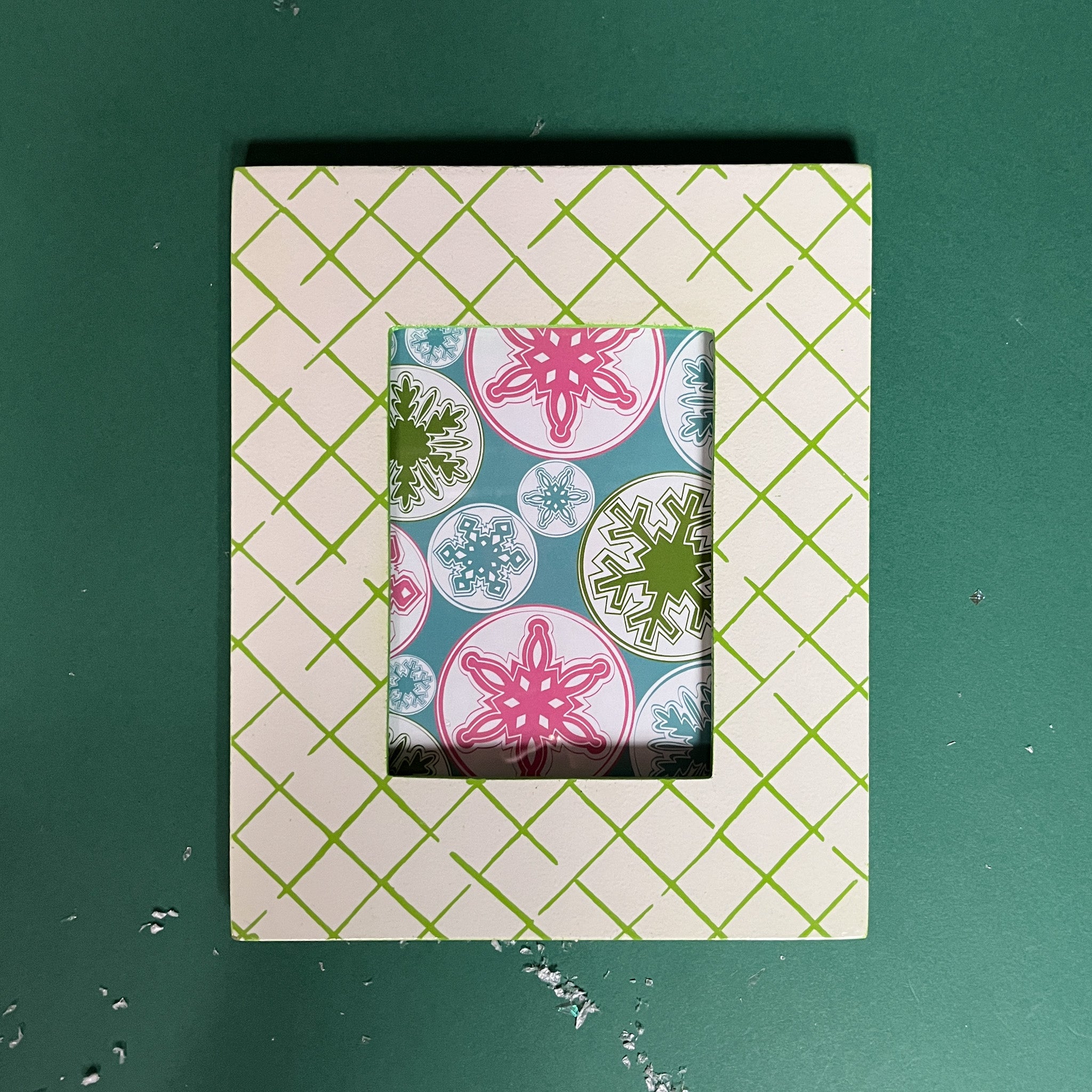 A green and white photo frame featuring a trellis pattern from madcap cottage