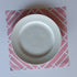 a pink paper placemat with a white bamboo design called island house by madcap cottage