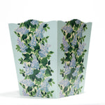 a blue floral wastepaper basket with a central repeating hydrangea pattern on each side. 