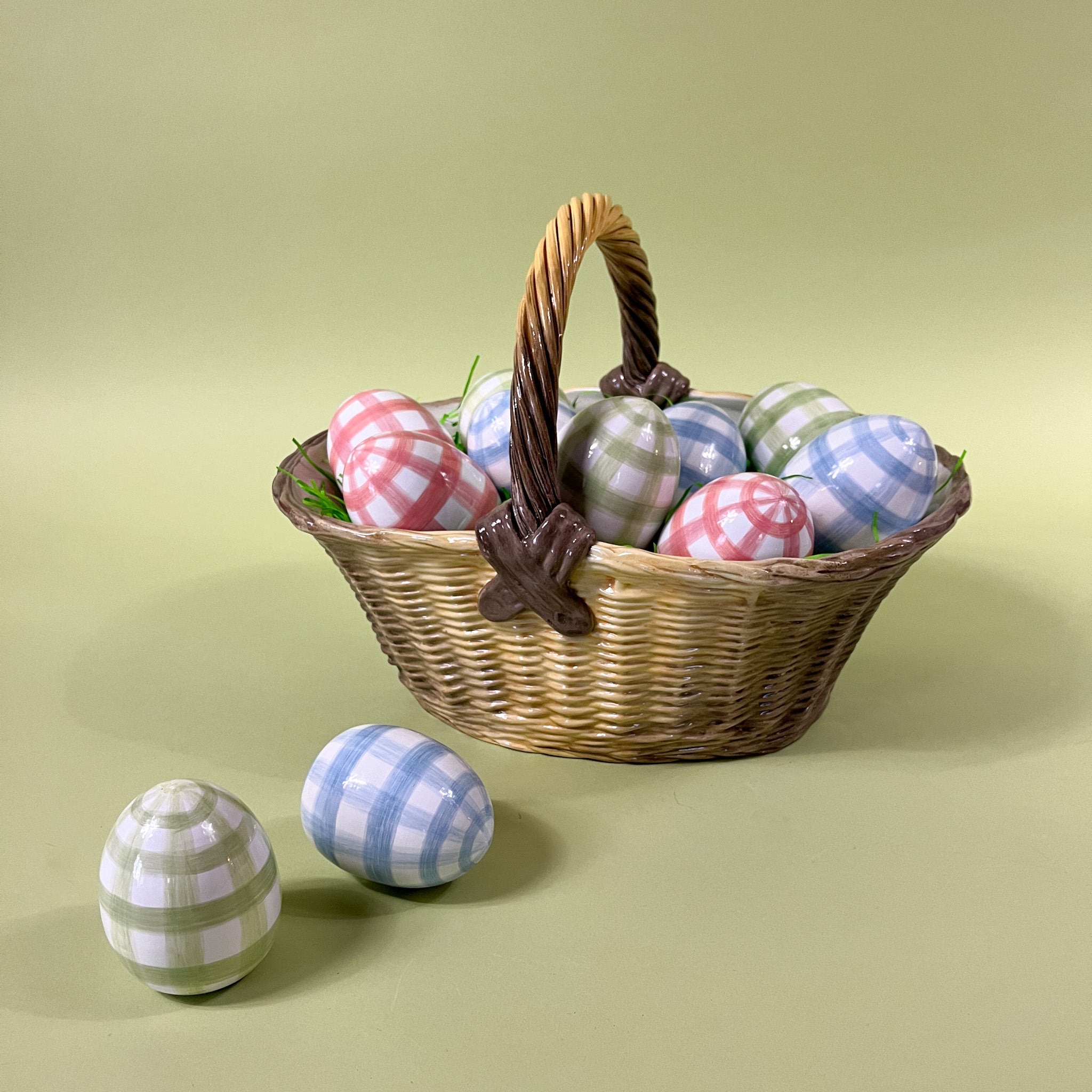 a basket filled with tole metal large decorative easter eggs printed with a gingham pattern.