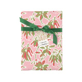 Elegant botanical gift wrap featuring lush green foliage, coral floral accents, and soft pink backgrounds.