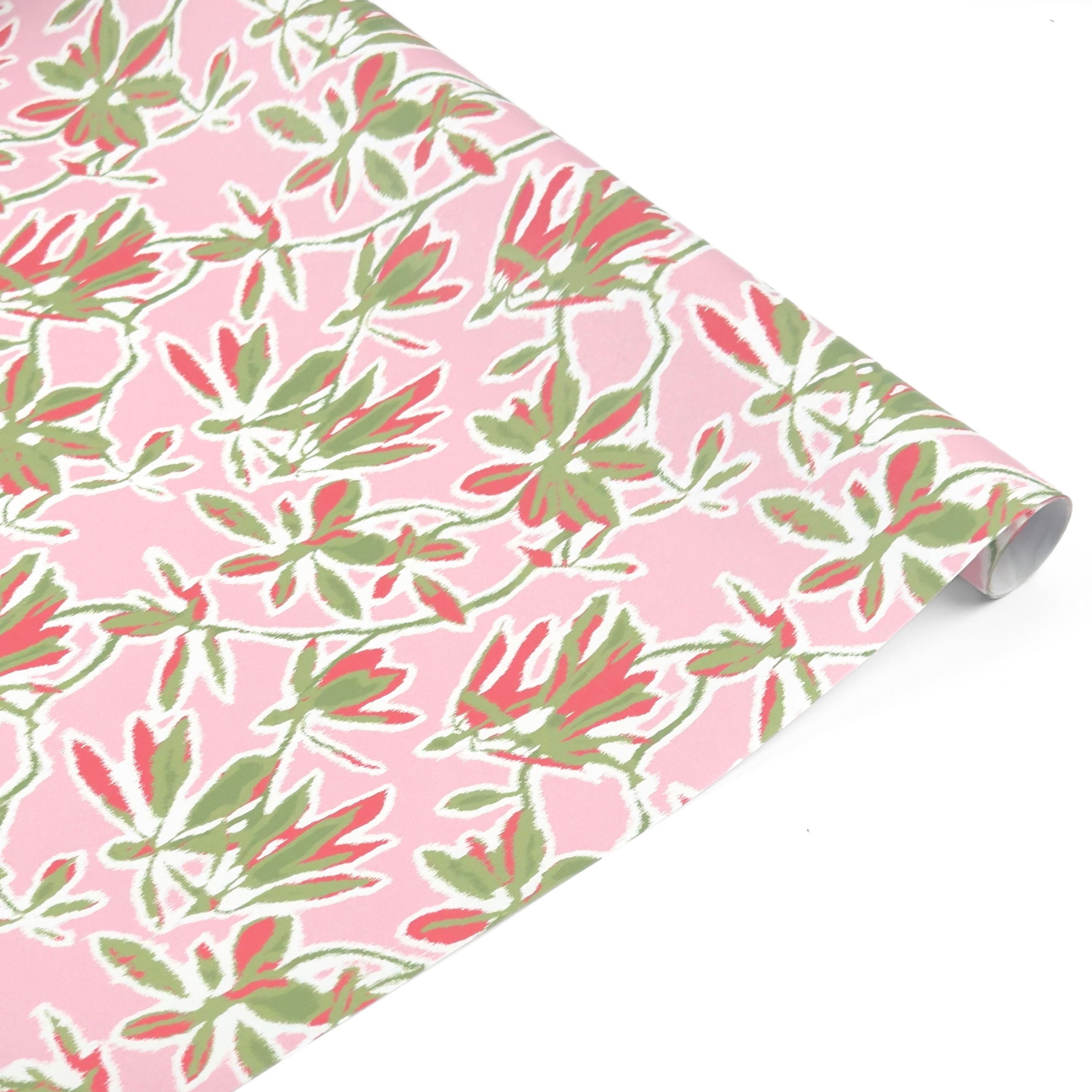 Elegant botanical gift wrap featuring lush green foliage, coral floral accents, and soft pink backgrounds.