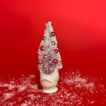 back of a white floral Vintage Ceramic Swan w/ Flocked Christmas Tree Centerpiece against a red background. 