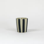 Ablack striped ceramic cup in on a white background. 