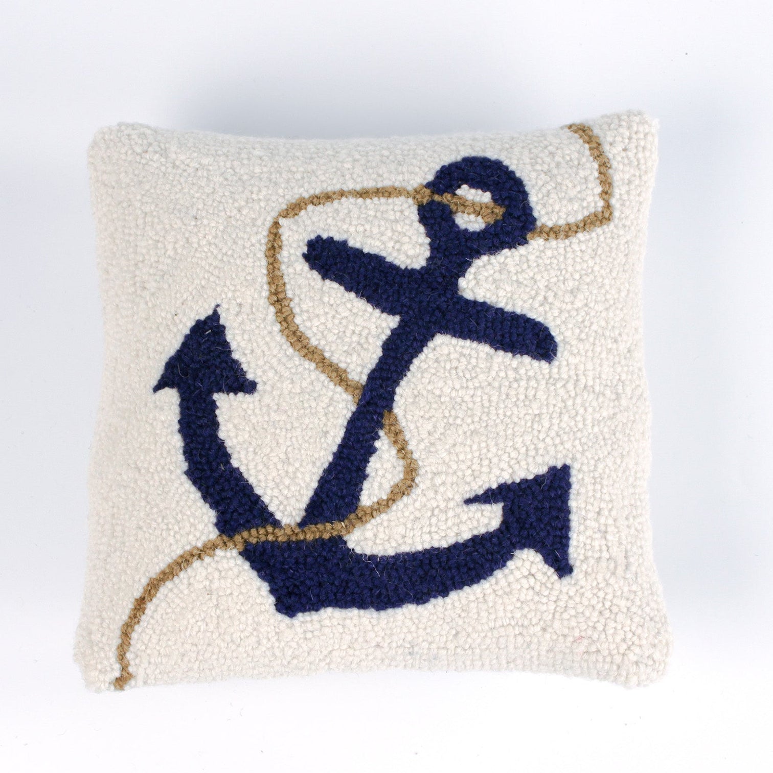 A white pillow featuring a dark blue anchor design with a tan rope wrapped around it.