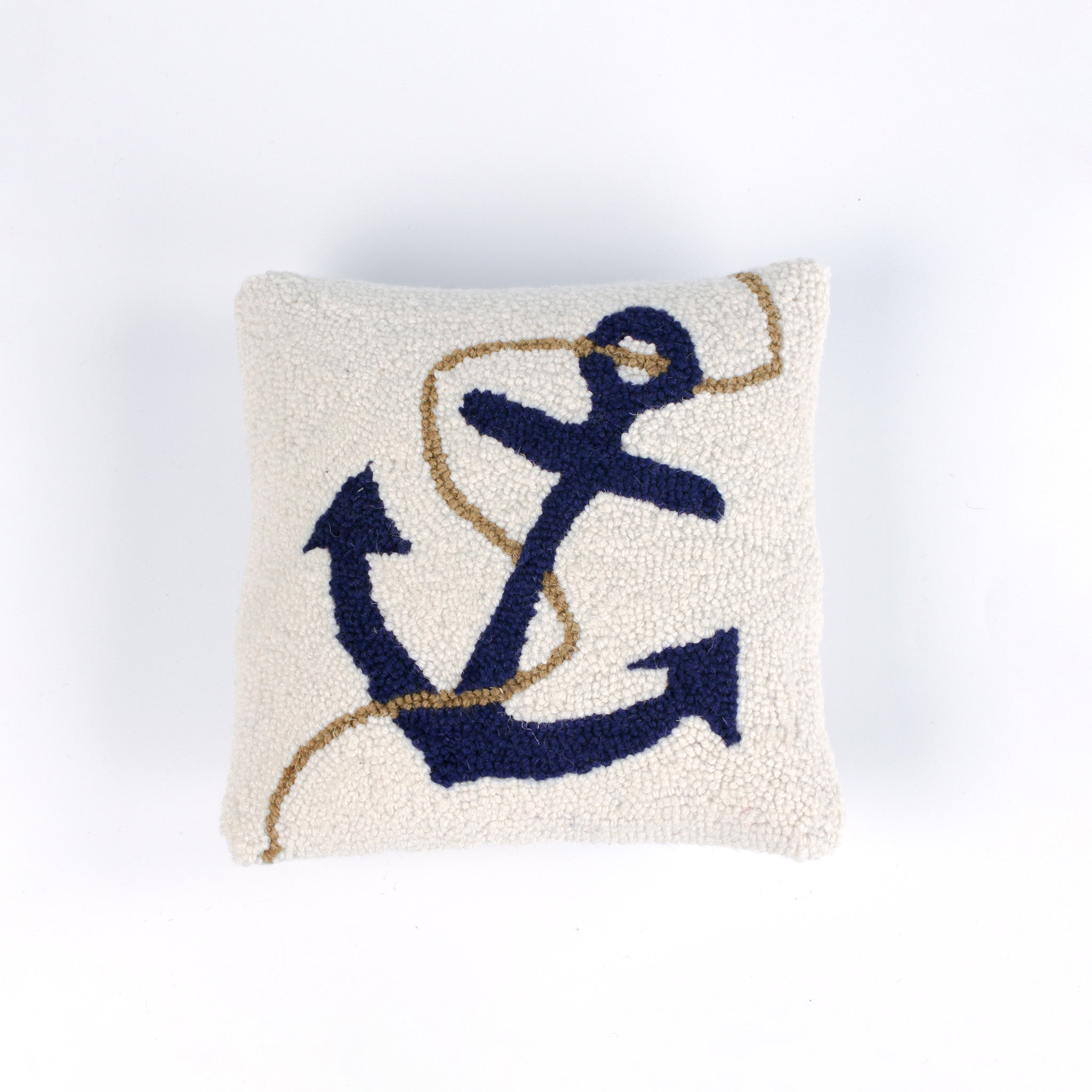 A white pillow featuring a dark blue anchor design with a tan rope wrapped around it.