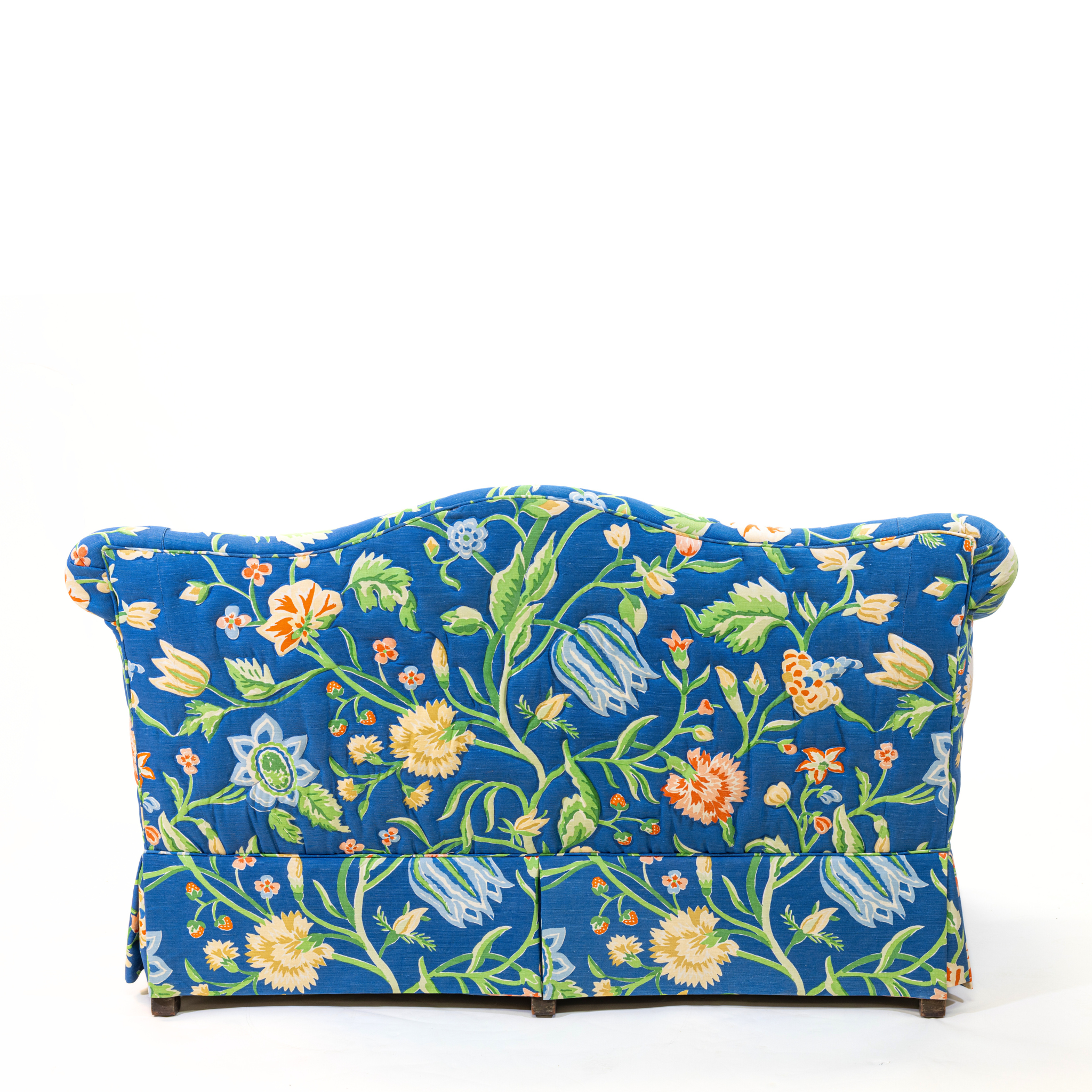 Back of Blue floral upholstered loveseat with botanical pattern and rolled arms
