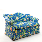 Blue floral upholstered loveseat with botanical pattern and rolled arms