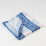 Close-up of folded blue and white striped cloth napkins with red scalloped trim.
