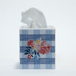 a blue gingham tissue box cover with a central floral motif on the front.