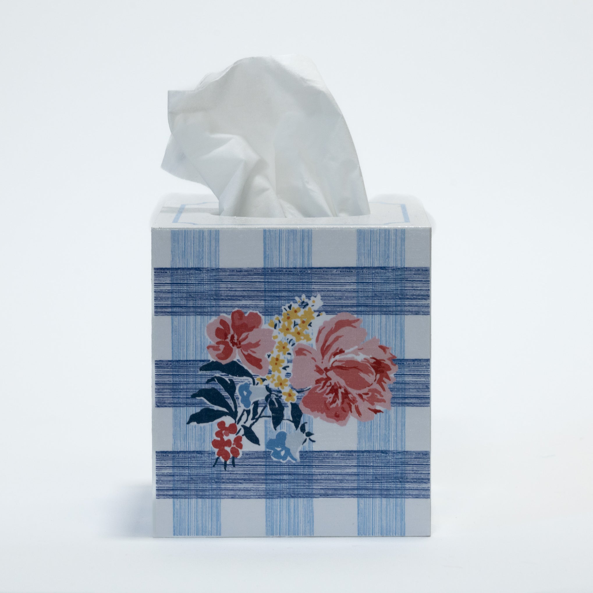 a blue gingham tissue box cover with a central floral motif on the front.