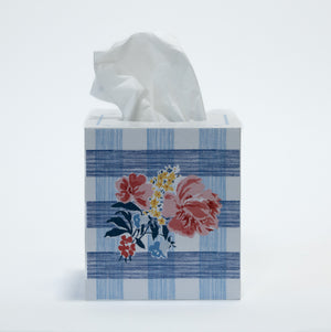 a blue gingham tissue box cover with a central floral motif on the front.