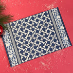 blue lattice patterned paper placemat with decorative border on table setting