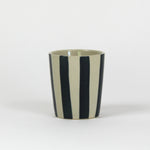 A blue striped ceramic cup in on a white background. 