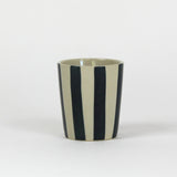 A blue striped ceramic cup in on a white background. 