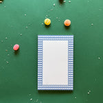 a luxury notepad with a blue gingham border