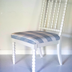A white bobbin chair with a blue plaid seat