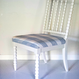 A white bobbin chair with a blue plaid seat