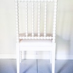 the back view of a white bobbin chair