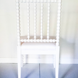 the back view of a white bobbin chair