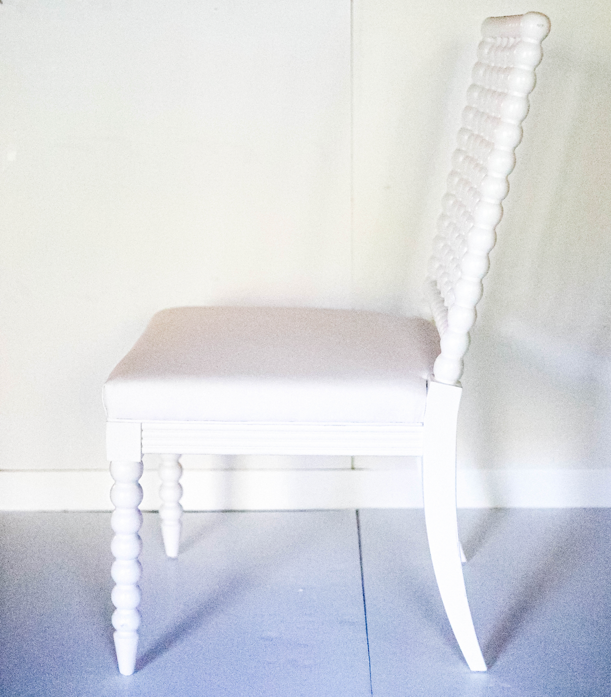 a side view of a white bobbin chair