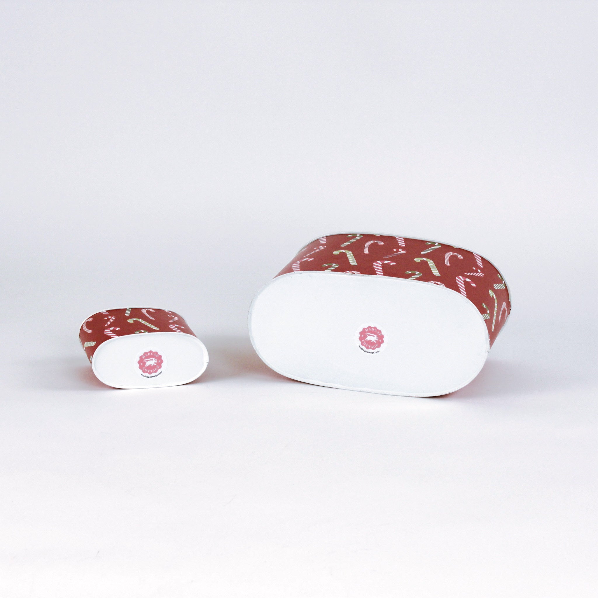 Two decoupage Dancing Candy Canes Christmas caddies with a candy cane pattern, one large and one small, placed on a white background. Showing their bottom