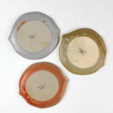 reverse side of citrus fruit shaped ceramic plates with decorative citrus patterns on a white background