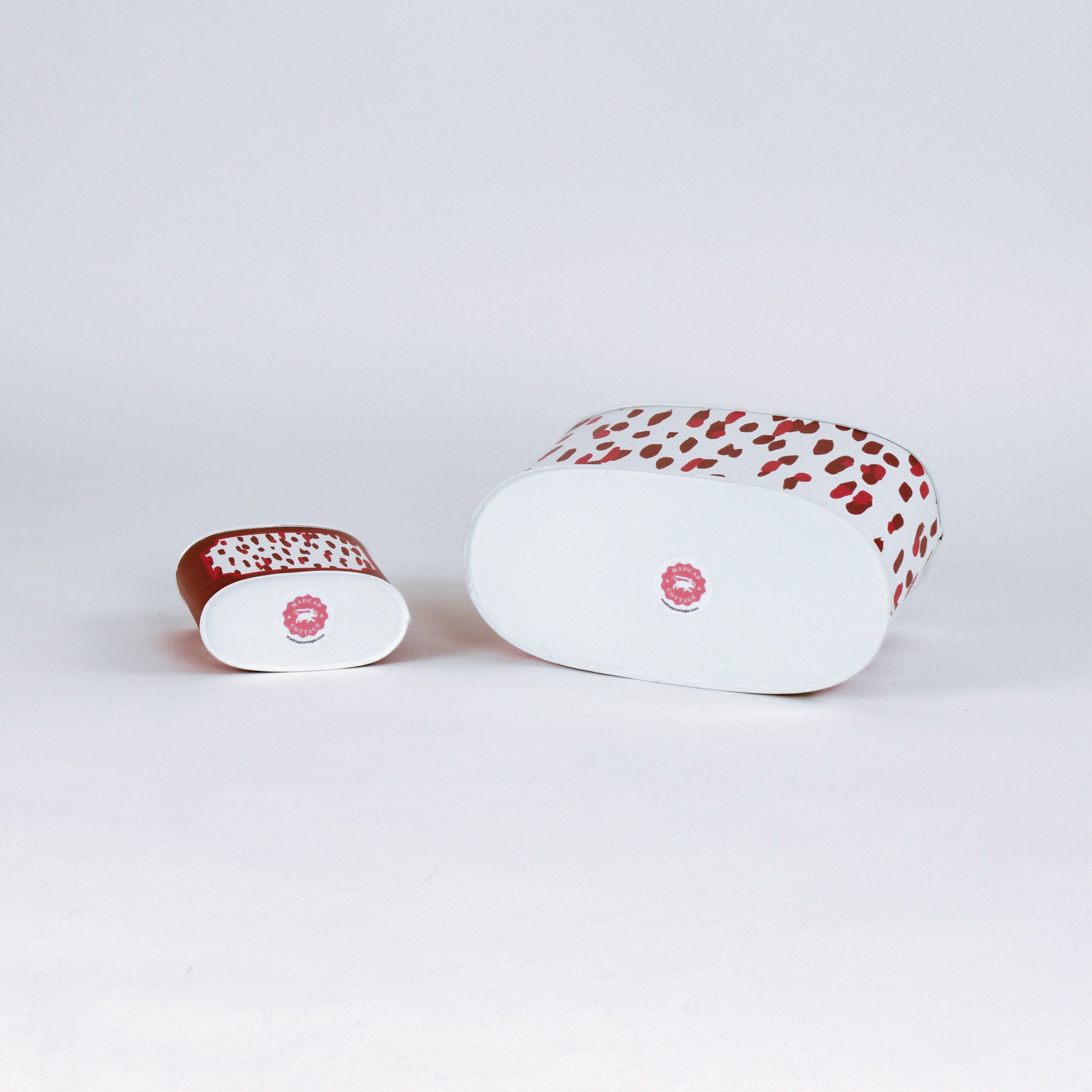 bottom of 2 madcap Cottage caddies with red abstract patterns on a white background