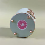 the bottom side of a green tole cachepot with a pink madcap cottage sticker on it