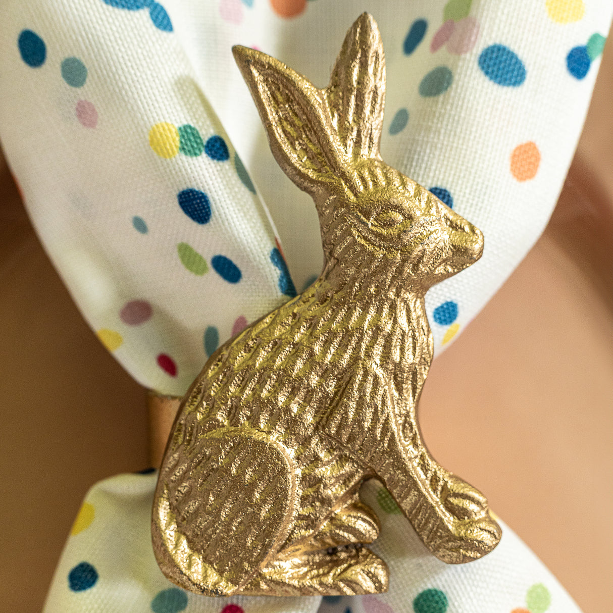 a bunny napkin ring holding a Springtime confetti multicolor cloth dinner napkin from Madcap Cottage.