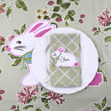 Easter-themed place setting with a bunny placemat and matching bunny place card on a floral background