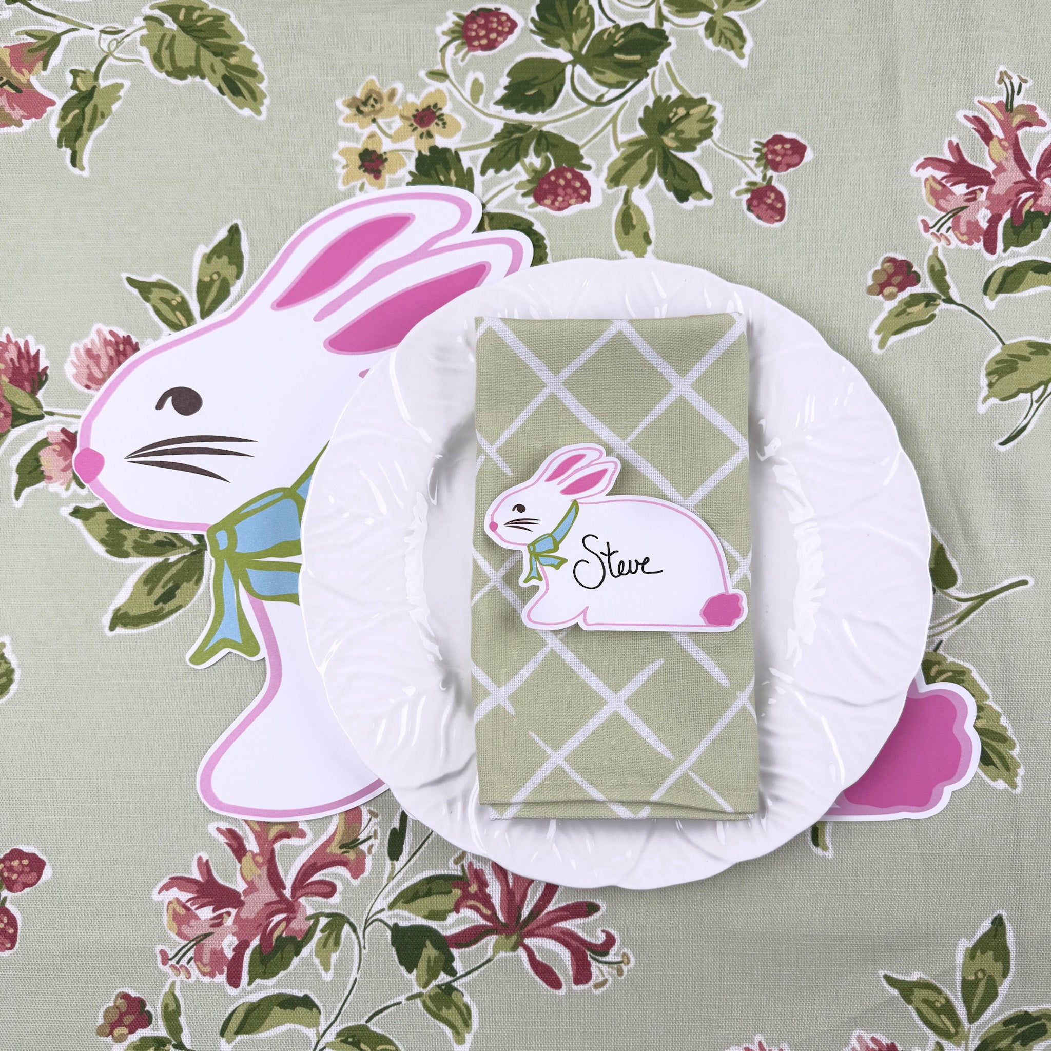 Easter-themed place setting with a bunny placemat and matching bunny place card on a floral background