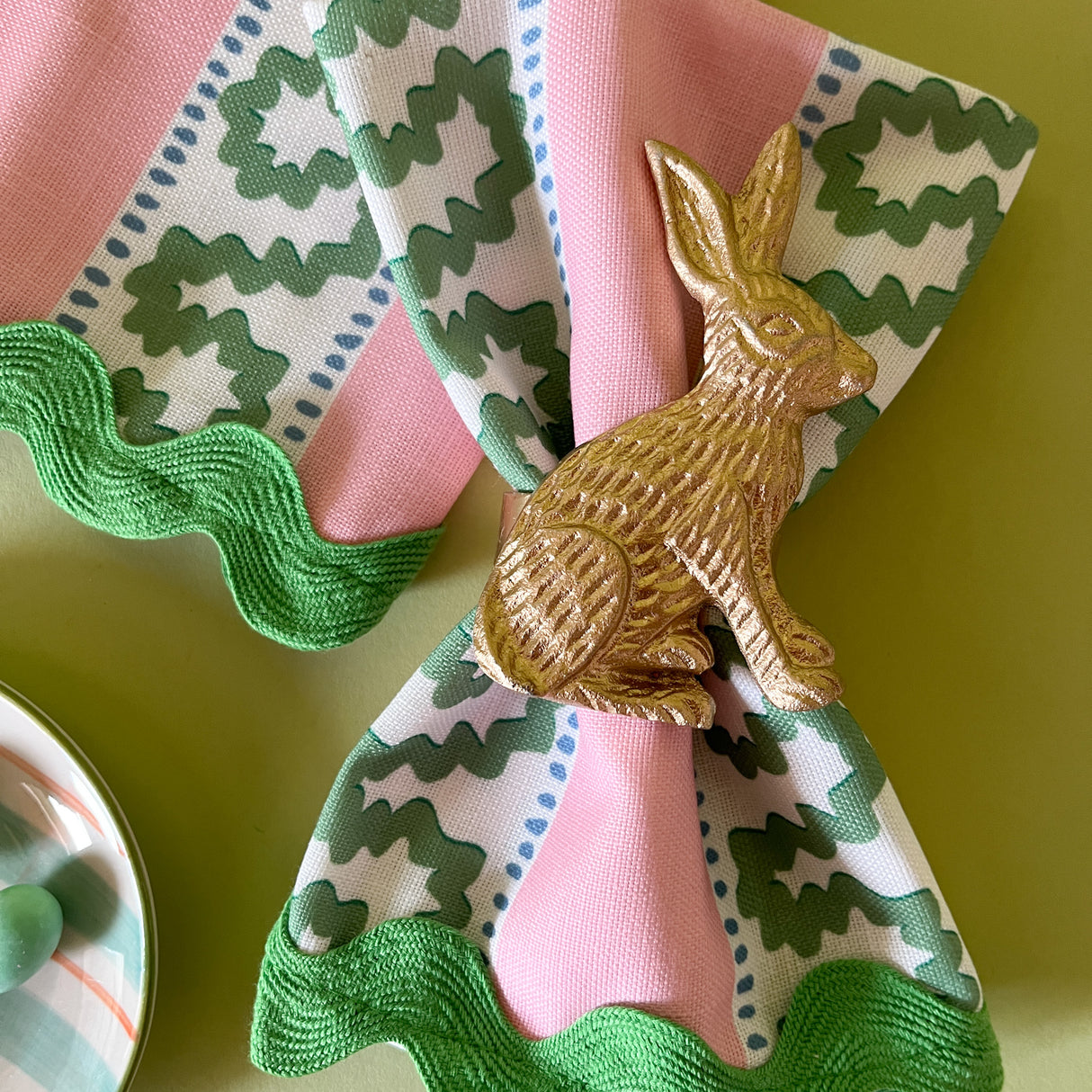green and pink dinner napkins in the pink striped harbor trail pattern fabric from madcap cottage with a gold bunny napkin ring
