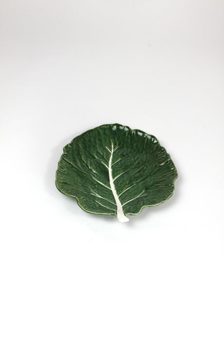 a ceramic green cabbage leaf plate on a white background.