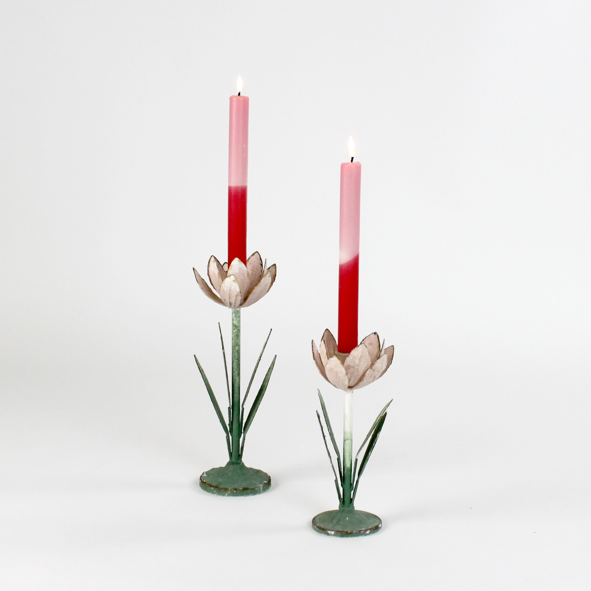 Two decorative metal Pink Tulip flower sculptures with colorful candles on a white background