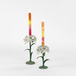 Two decorative metal hydrangea flower sculptures with colorful candles on a white background