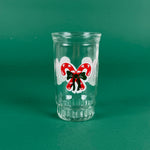 Clear holiday tumbler with red candy cane bow design on a green background