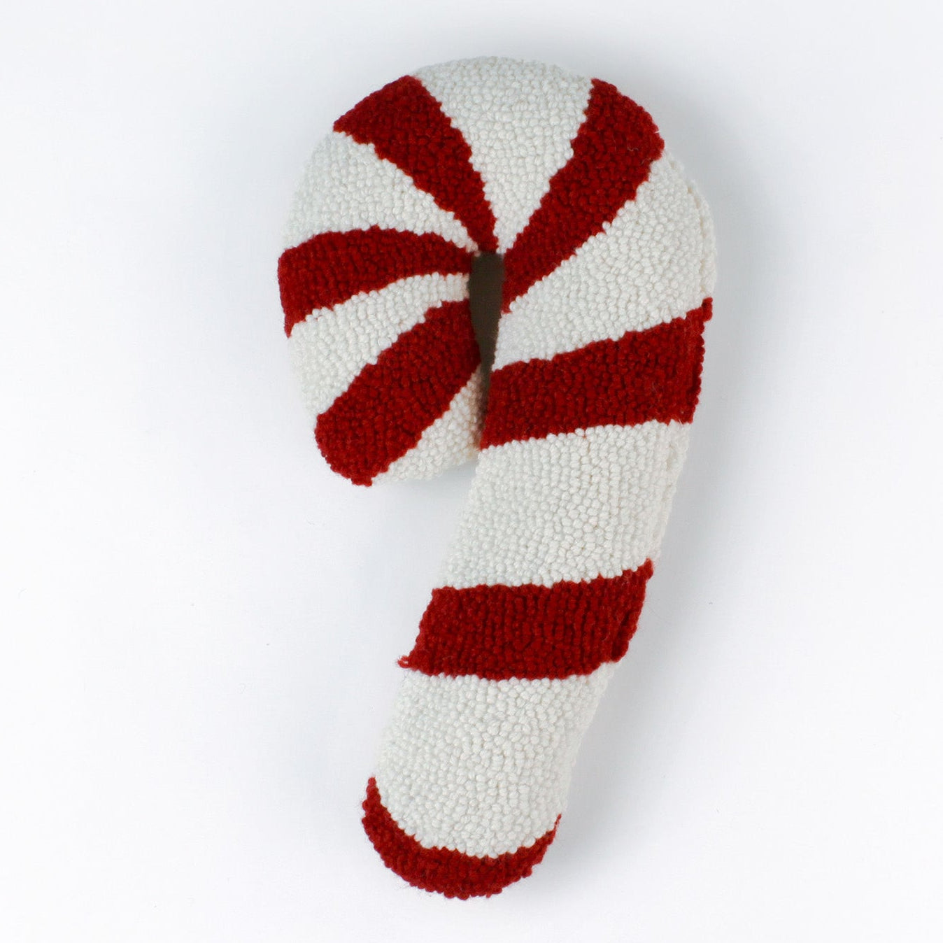 Candy cane–shaped decorative Christmas pillow with red and white stripes, made from a textured hooked fabric and displayed against a white background.