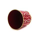 Red tole cachepot with gold trim and candy cane design, shown on its side to display interior.