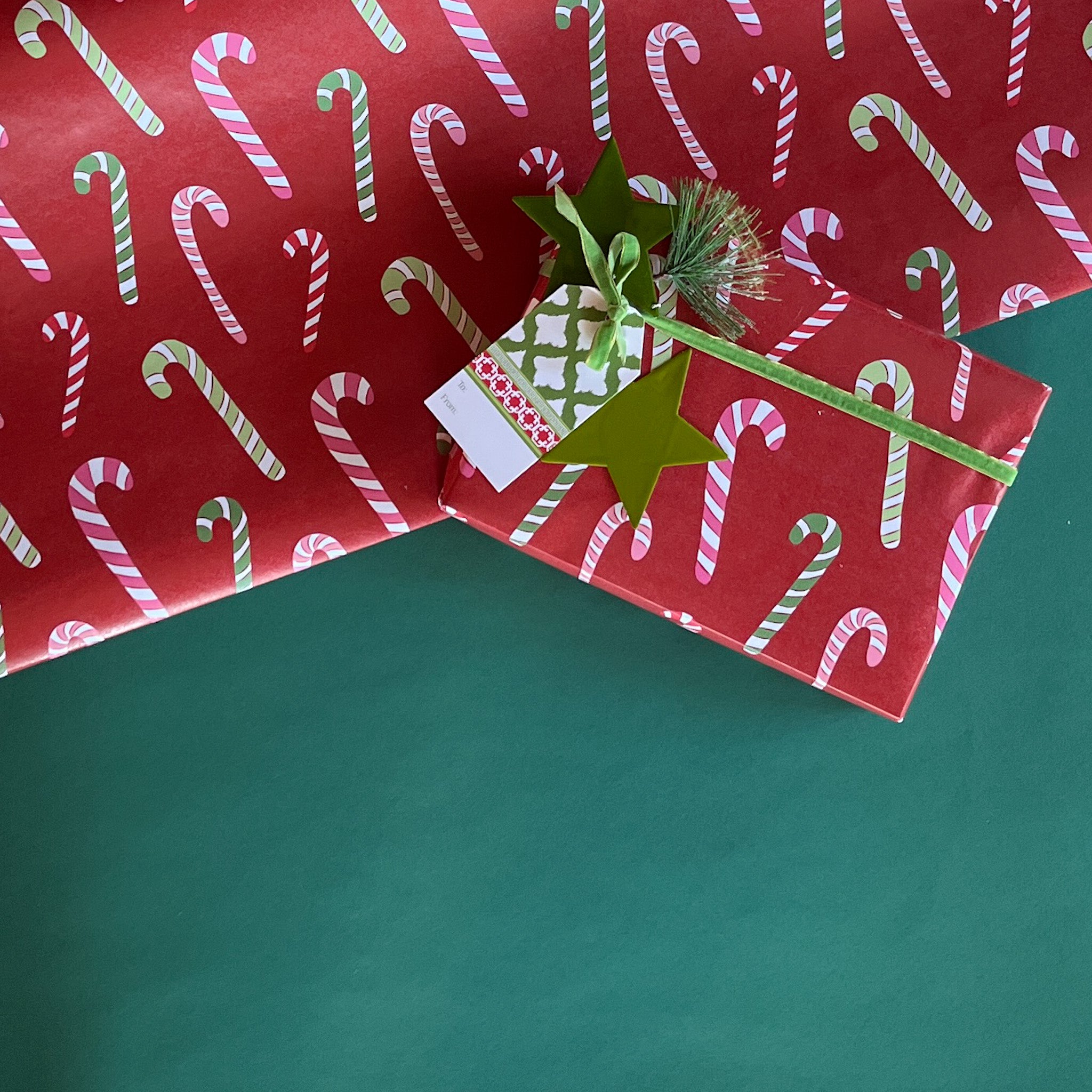 colorful Christmas wrapping paper featuring candy canes on a red background